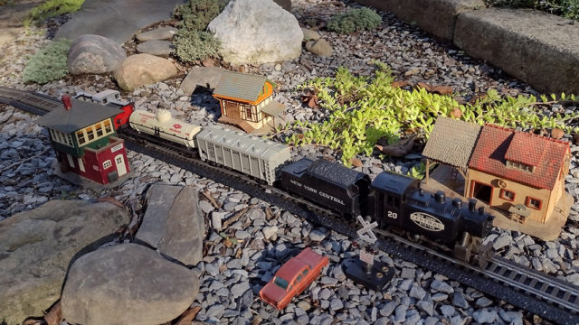 HO train set in backyard landscape