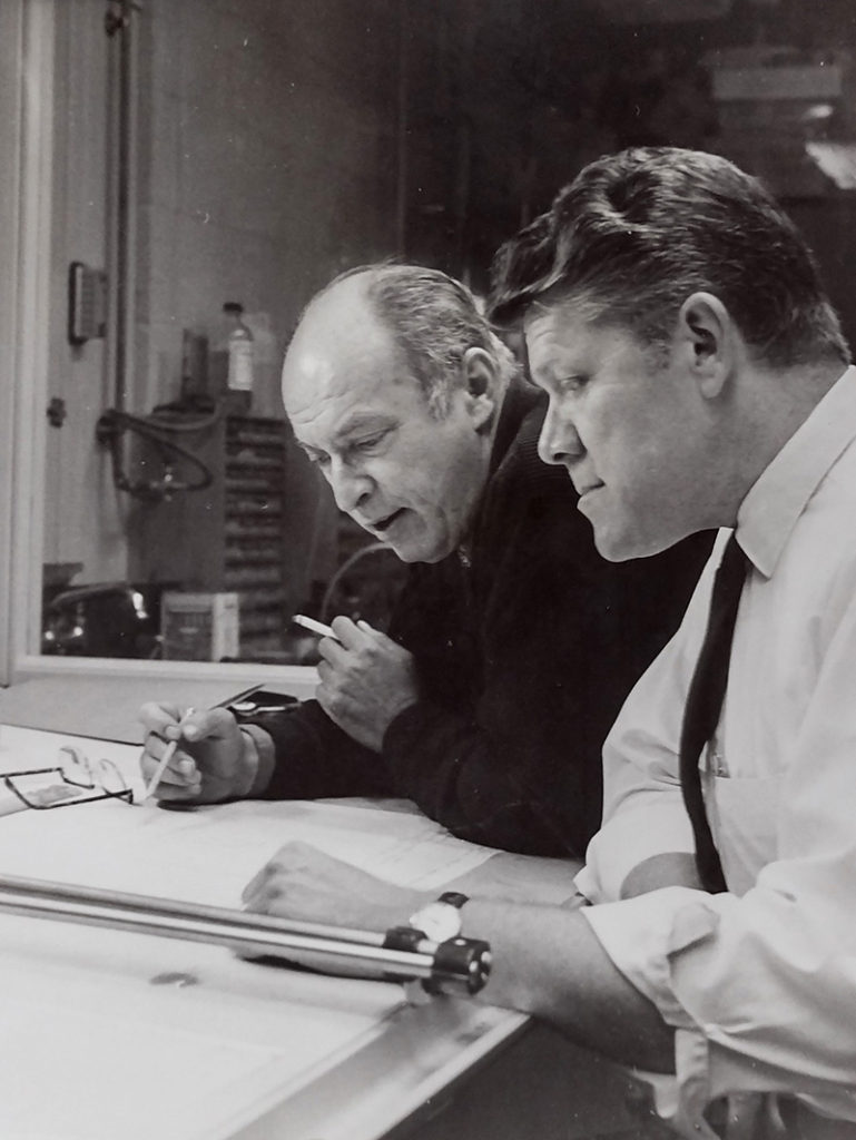 Black and white photograph of L. A. Hall and Hans Hinteregger in 1970, examining a scientific blueprint